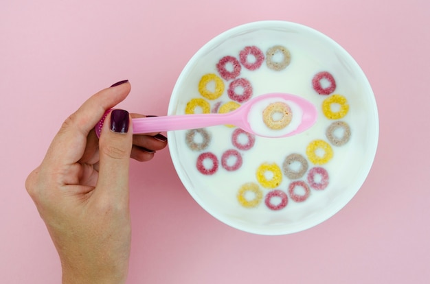 Mujer sosteniendo una cuchara con un cereal de bucle de frutas