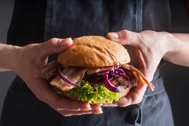 Mujer sosteniendo una deliciosa hamburguesa