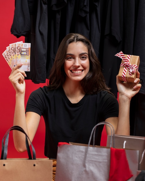 Mujer sosteniendo dinero y regalo envuelto