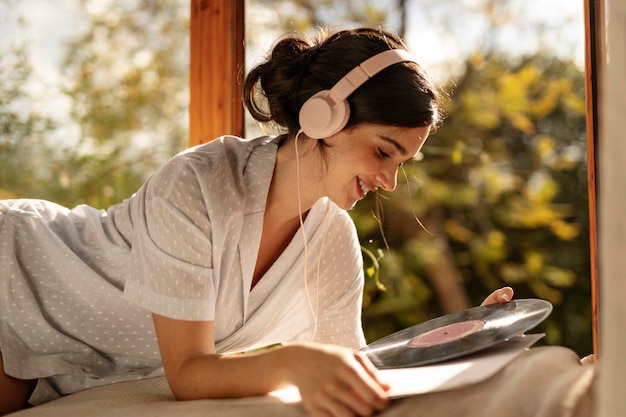 Mujer sosteniendo disco de vinilo de tiro medio