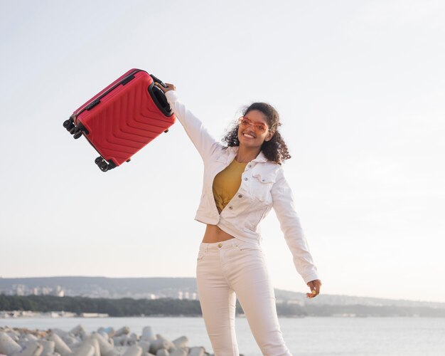 Mujer sosteniendo el equipaje de tiro medio