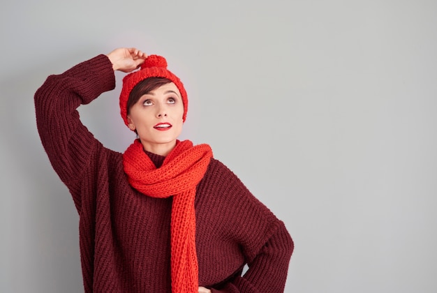 Foto gratuita mujer sosteniendo el extremo de su gorro de invierno