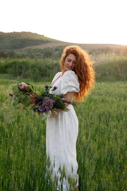 Foto gratuita mujer sosteniendo flor boho