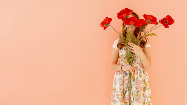 Mujer sosteniendo flores rojas