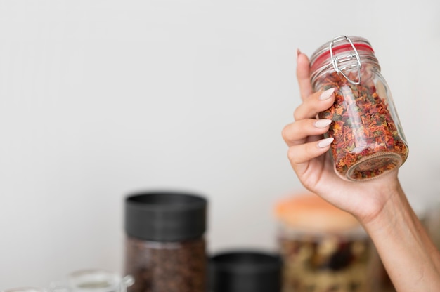 Mujer sosteniendo un frasco con especias con espacio de copia