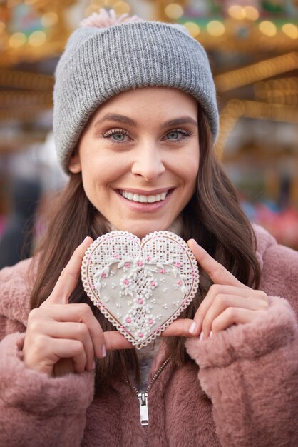 Mujer sosteniendo una galleta de jengibre en forma de corazón