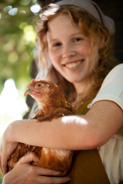 Mujer sosteniendo gallina de cerca