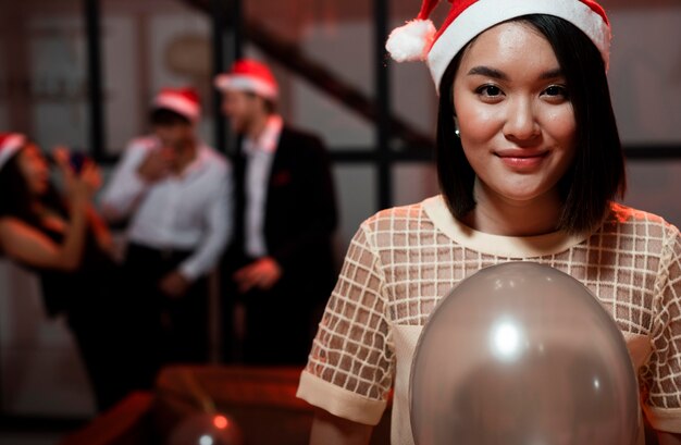 Mujer sosteniendo un globo en la fiesta de fin de año