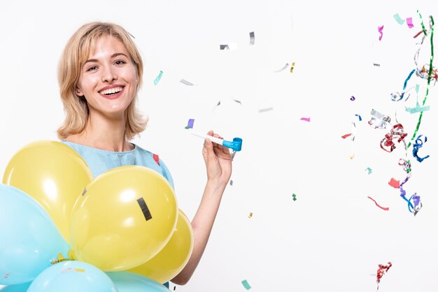 Mujer sosteniendo globos rodeados de confeti