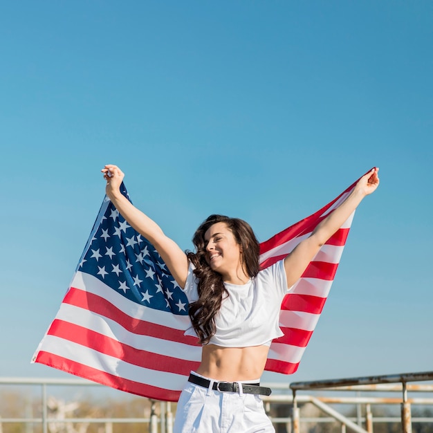 Mujer sosteniendo gran bandera de Estados Unidos