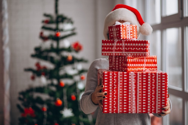 Mujer sosteniendo grandes cajas de navidad