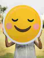 Foto gratuita mujer sosteniendo un icono de cara sonriente