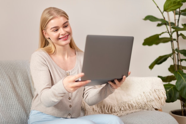 Mujer sosteniendo laptop tiro medio