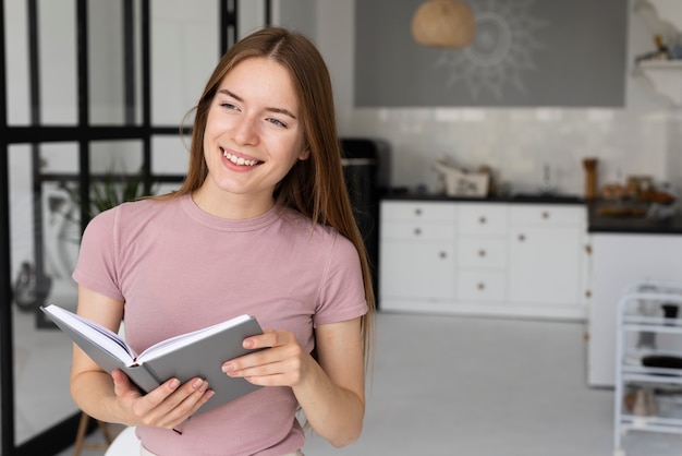 Mujer sosteniendo un libro mientras mira lejos