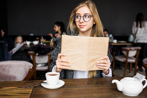 Mujer sosteniendo el libro y mirando a otro lado