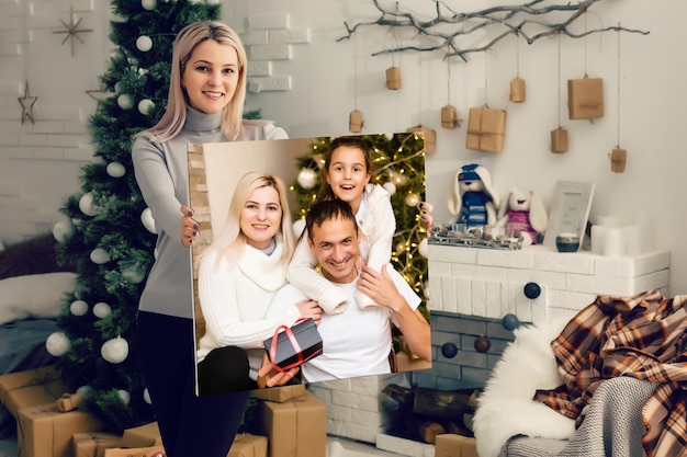 Mujer sosteniendo un lienzo fotográfico en el fondo de un interior navideño