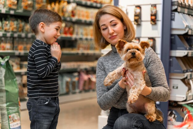Mujer sosteniendo un lindo perrito en la tienda de mascotas