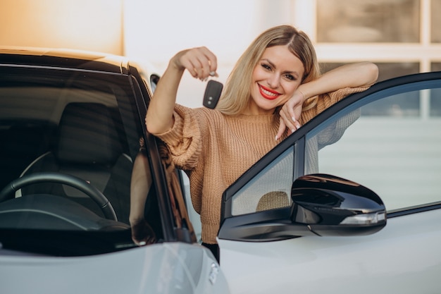 Mujer sosteniendo las llaves de su coche nuevo