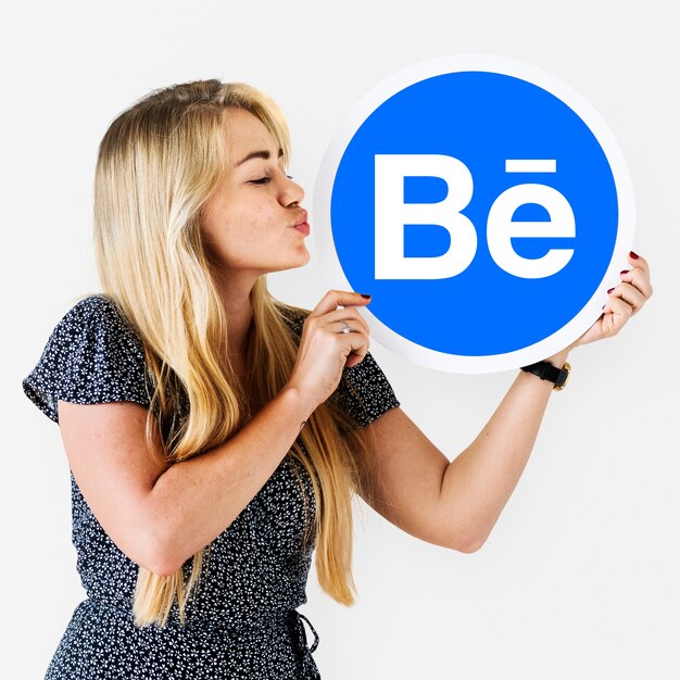 Mujer sosteniendo un logo de Behance.