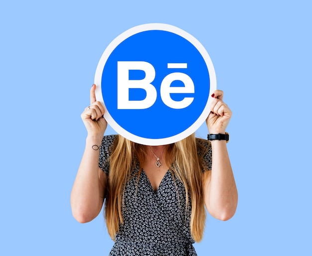 Foto gratuita mujer sosteniendo un logo de behance.