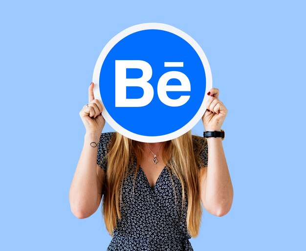 Mujer sosteniendo un logo de Behance.