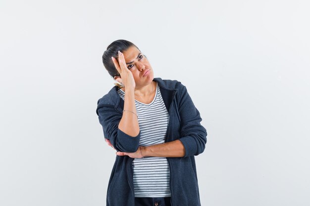 Mujer sosteniendo la mano en la cabeza en camiseta