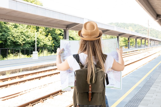 Mujer sosteniendo un mapa desde atrás