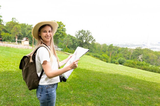 Mujer sosteniendo un mapa y sonriendo