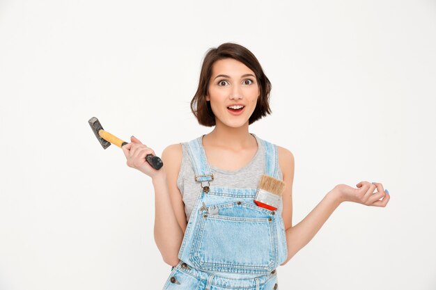 mujer sosteniendo martillo, renovando casa, edificio