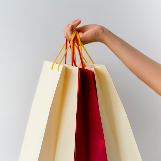 Mujer sosteniendo un montón de bolsas de la compra.