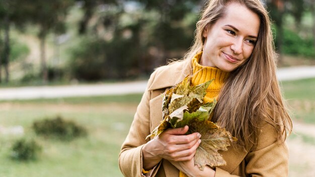 Mujer sosteniendo un montón de hojas