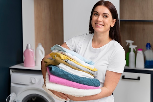 Mujer sosteniendo un montón de ropa limpia