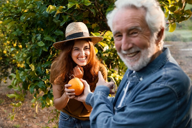 Mujer sosteniendo una naranja fresca con su papá