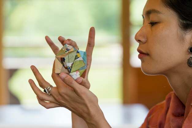 Mujer sosteniendo un objeto de origami