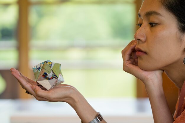 Mujer sosteniendo un objeto de origami