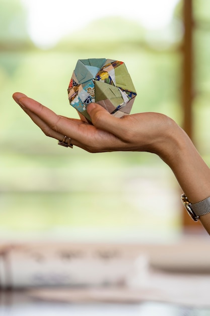 Mujer sosteniendo un objeto de origami