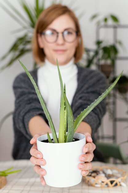 Mujer sosteniendo una olla de tiro medio