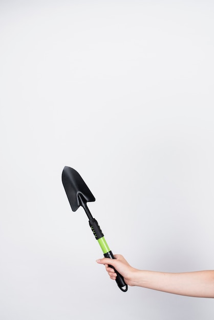 Mujer sosteniendo una pala negra con espacio de copia