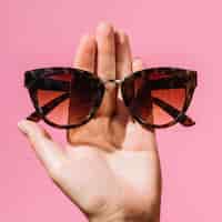 Foto gratuita mujer sosteniendo un par de anteojos de moda