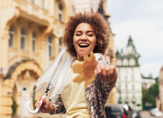 Mujer sosteniendo un paraguas transparente en otoño