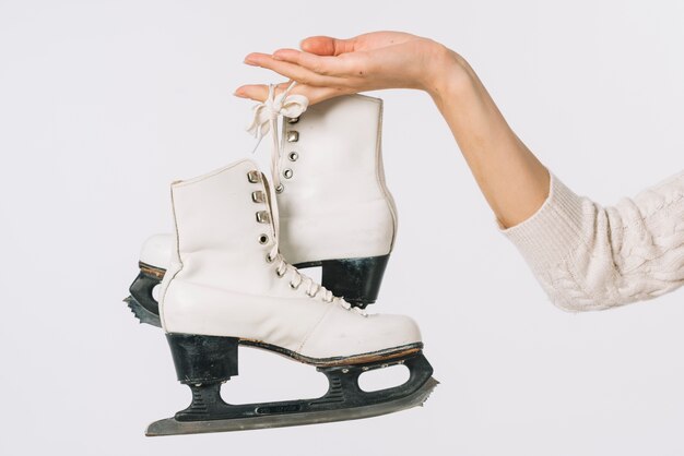 Mujer sosteniendo patines blancos en la mano