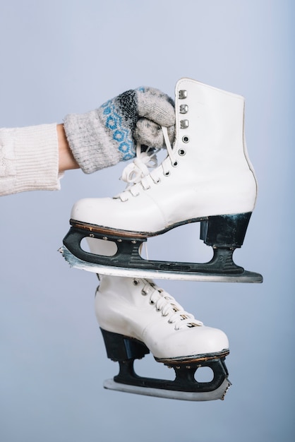 Foto gratuita mujer sosteniendo patines blancos en la mano