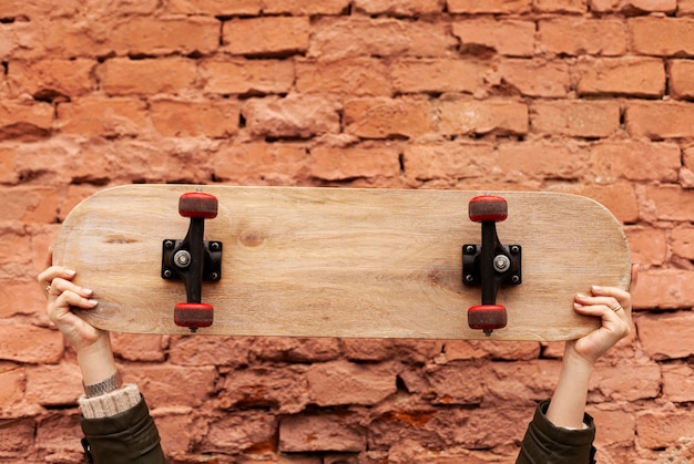 Mujer sosteniendo una patineta de madera