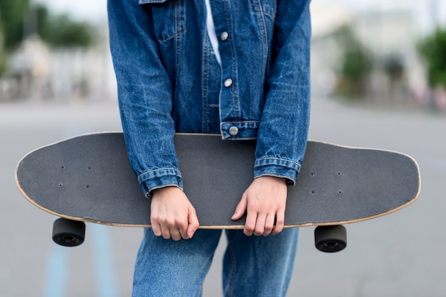 Foto gratuita mujer sosteniendo una patineta con sus manos