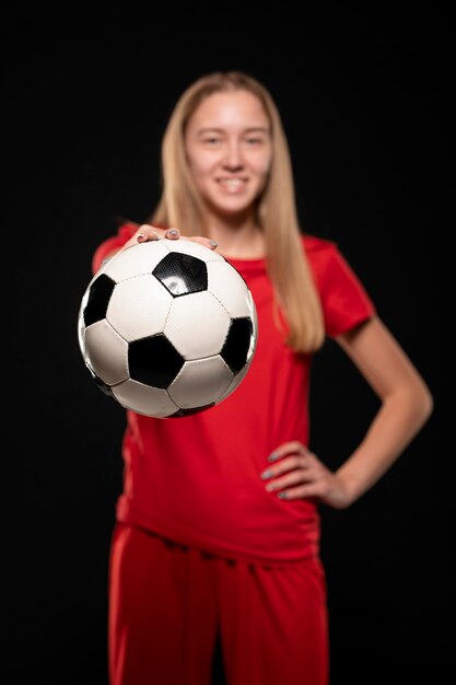 Mujer sosteniendo una pelota de fútbol