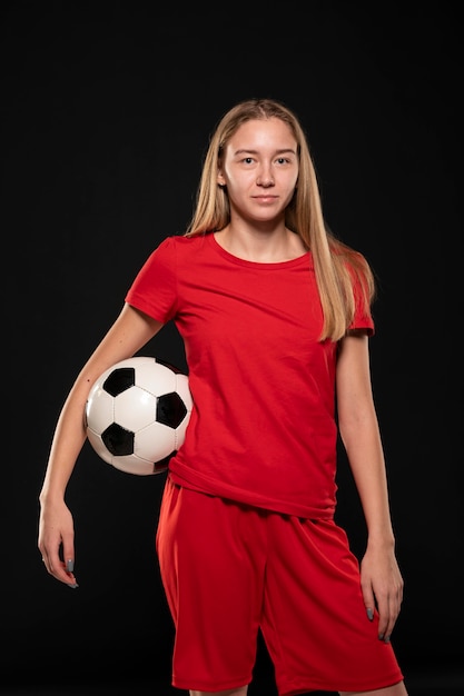 Mujer sosteniendo una pelota de fútbol