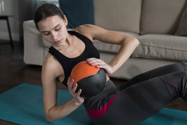 Mujer sosteniendo la pelota mientras hace ejercicio