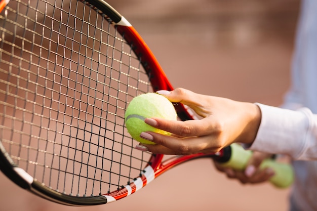 Foto gratuita mujer sosteniendo una pelota de tenis y raqueta