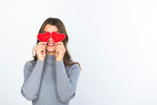 Mujer sosteniendo pequeños corazones en los ojos