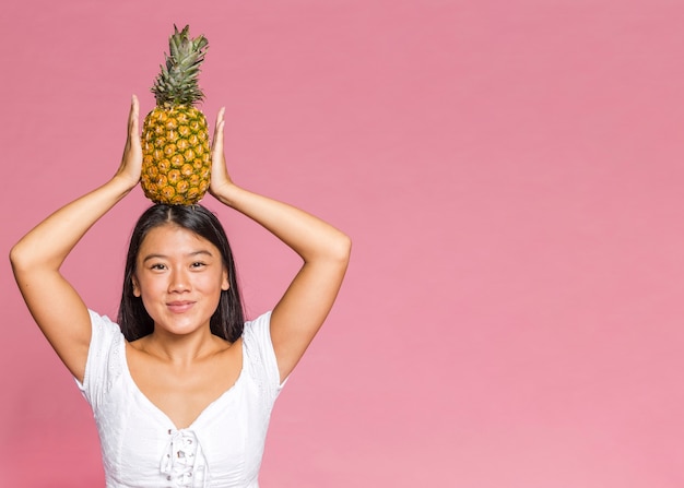 Mujer sosteniendo una piña con espacio de copia